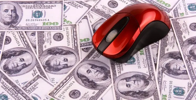 Picture is showing a computer mouse on a lot of cash (US Dollars)